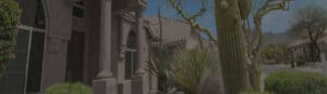 A house with cactus trees in front of it, featuring pristine windows and impeccable glass repair.
