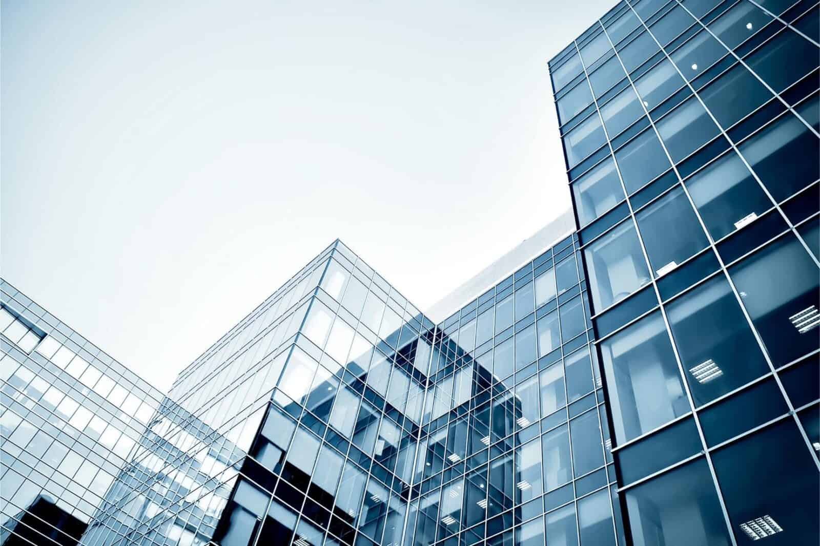 Modern glass buildings with custom commercial gym mirrors in the background, reflecting a cool, monochromatic color tone.